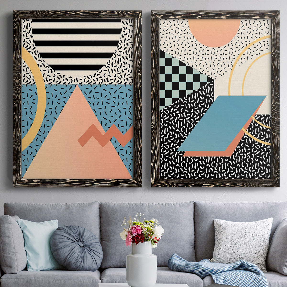 Set of two black barnwood framed canvas prints depicting paired retro graphic abstracts with checkerboards stripes squiggles peach blue black and mint shapes above a sofa in a contemporary living room.
