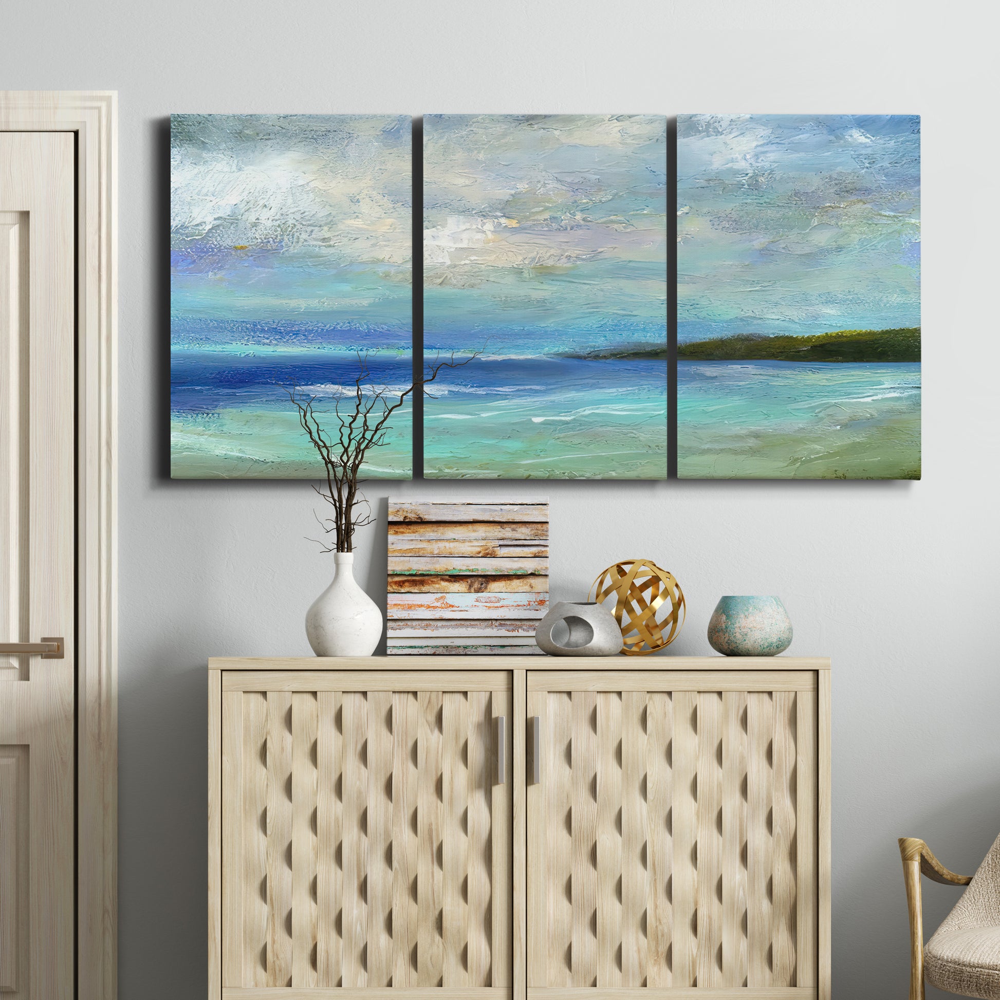 Three-panel canvas wall art featuring narrow island inlet waters, displayed above a cabinet in an entryway.