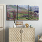Three-panel canvas wall art featuring cliffside cottage overlooking sea, displayed above a cabinet in an entryway.