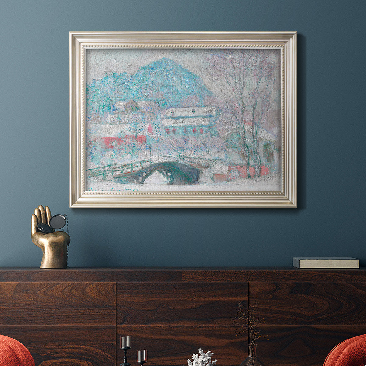 Impressionist coastal village landscape in Norway by Claude Monet in an ornate champagne frame displayed in a dark-toned interior setting.