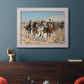 Impressionist western action scene by Frederic Remington in an ornate weathered white frame displayed in a dark-toned interior setting.