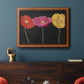 Contemporary poppy flower artwork in an ornate vintage burl wood frame displayed in a dark-toned interior setting.
