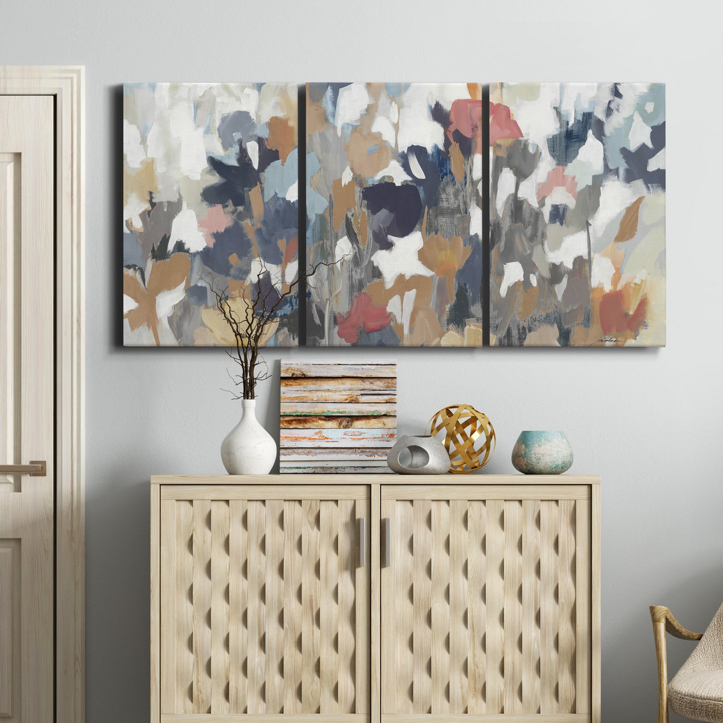 Three-panel canvas wall art featuring abstract flower stand composition, displayed above a cabinet in an entryway.
