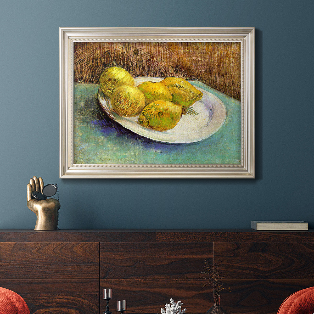 Impressionist still life with lemons by Vincent van Gogh in an ornate champagne frame displayed in a dark-toned interior setting.