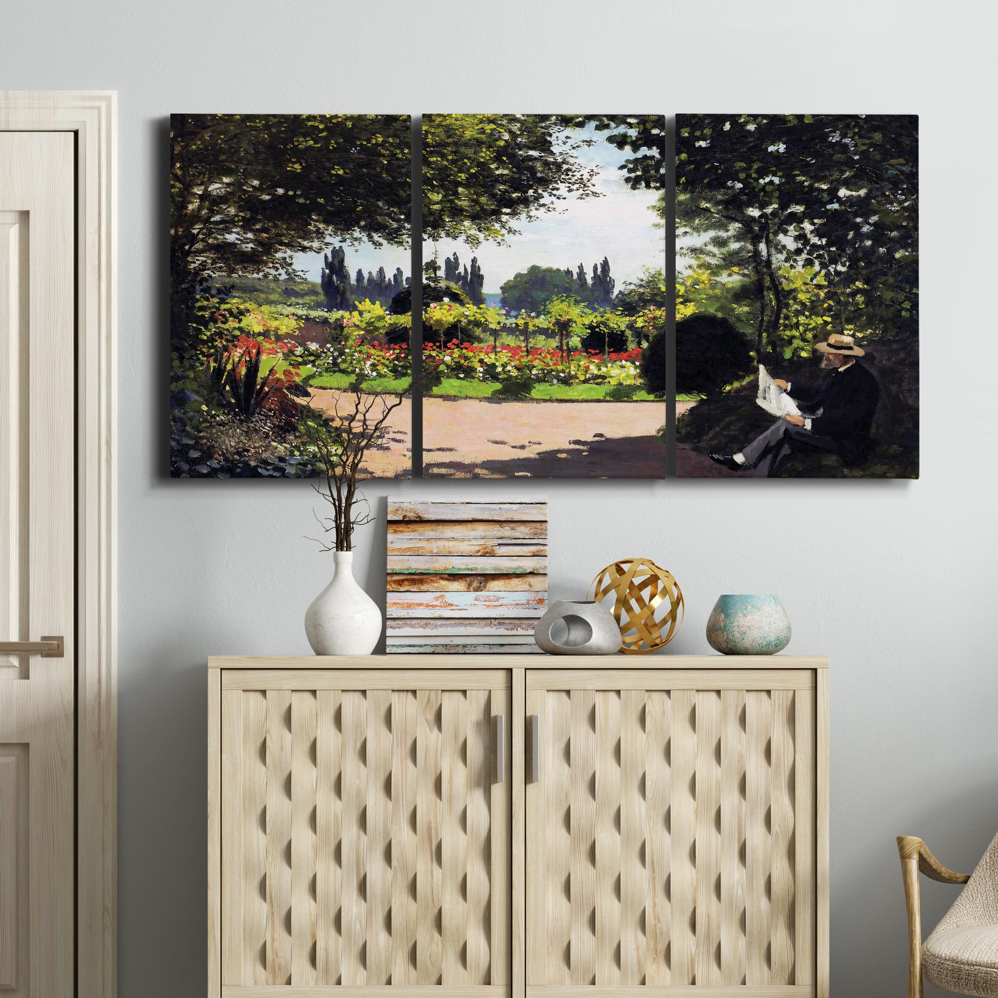 Three-panel canvas wall art featuring coastal garden overlooking sea, displayed above a cabinet in an entryway.