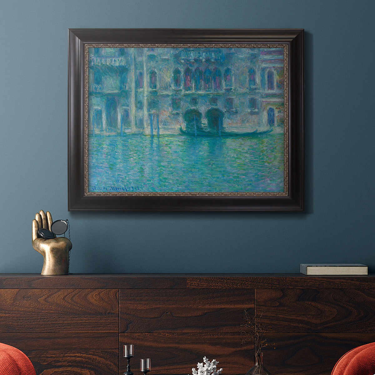 Impressionist Venetian palace waterfront scene by Claude Monet in an ornate black frame with gilded inner detail displayed in a dark-toned interior setting.