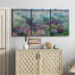 Three-panel canvas wall art featuring flowered riverbank with trees, displayed above a cabinet in an entryway.