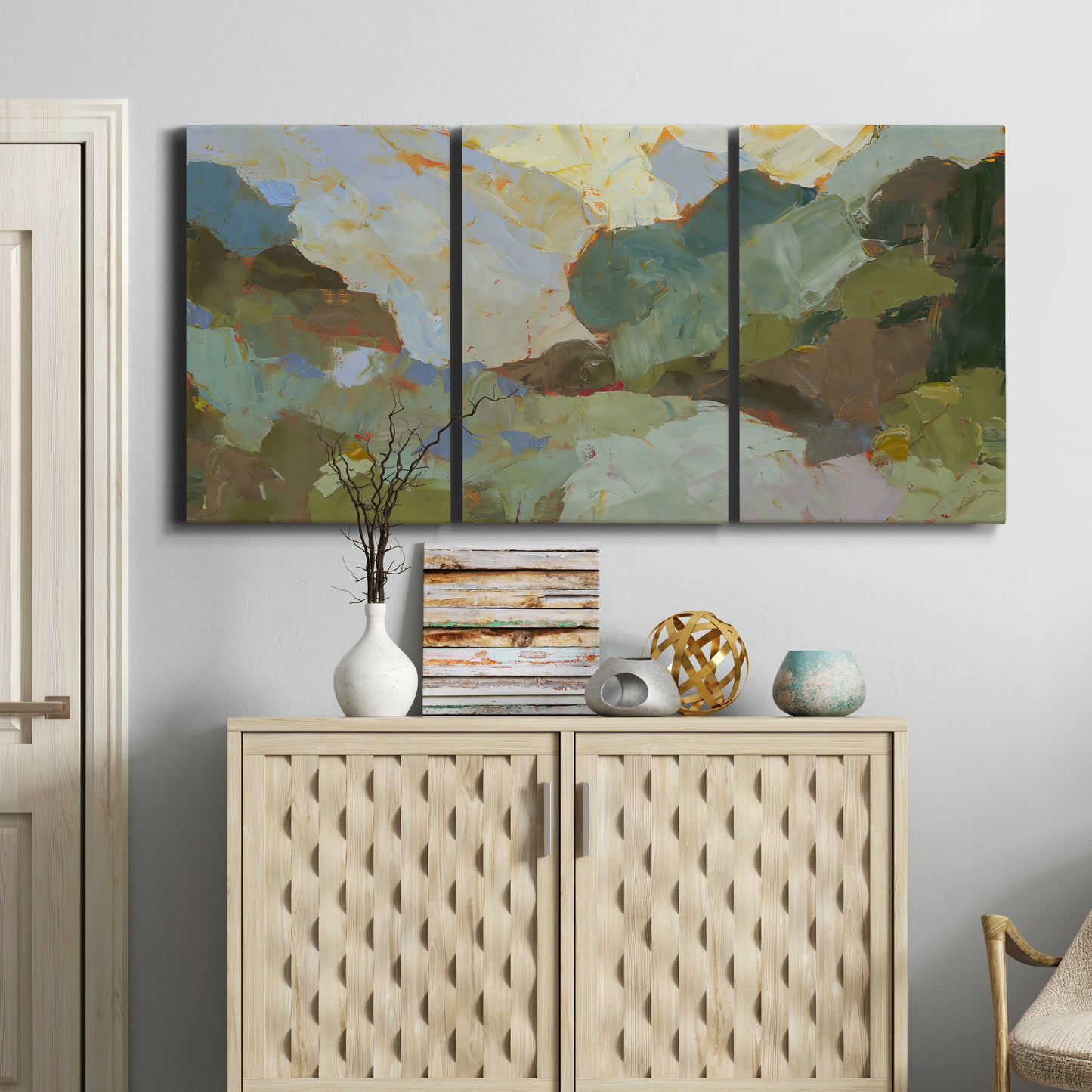 Three-panel canvas wall art featuring abstract landscape suggesting travel pause, displayed above a cabinet in an entryway.