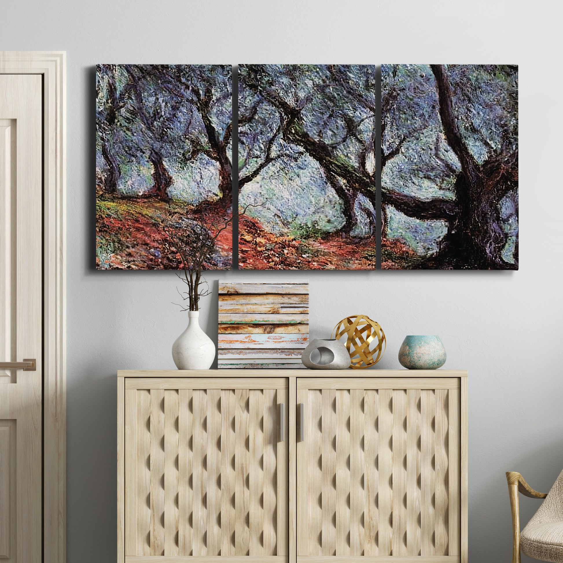 Three-panel canvas wall art featuring pine trees silhouetted at evening, displayed above a cabinet in an entryway.
