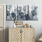 Three-panel canvas wall art featuring indigo floral abstraction, displayed above a cabinet in an entryway.