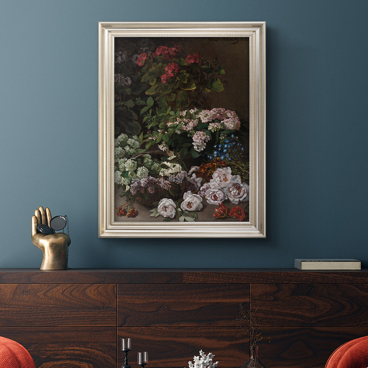 Early impressionist floral painting by Claude Monet in an ornate champagne frame displayed in a dark-toned interior setting.