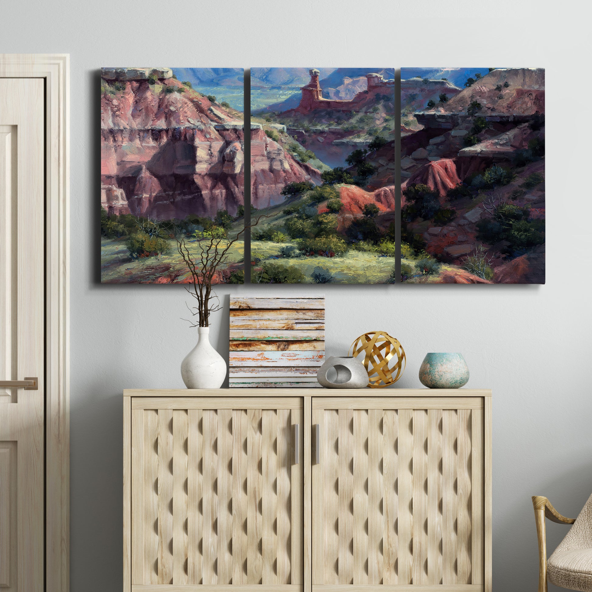 Three-panel canvas wall art featuring classic canyon landscape scene, displayed above a cabinet in an entryway.