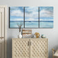 Three-panel canvas wall art featuring tropical clouds over ocean horizon, displayed above a cabinet in an entryway.