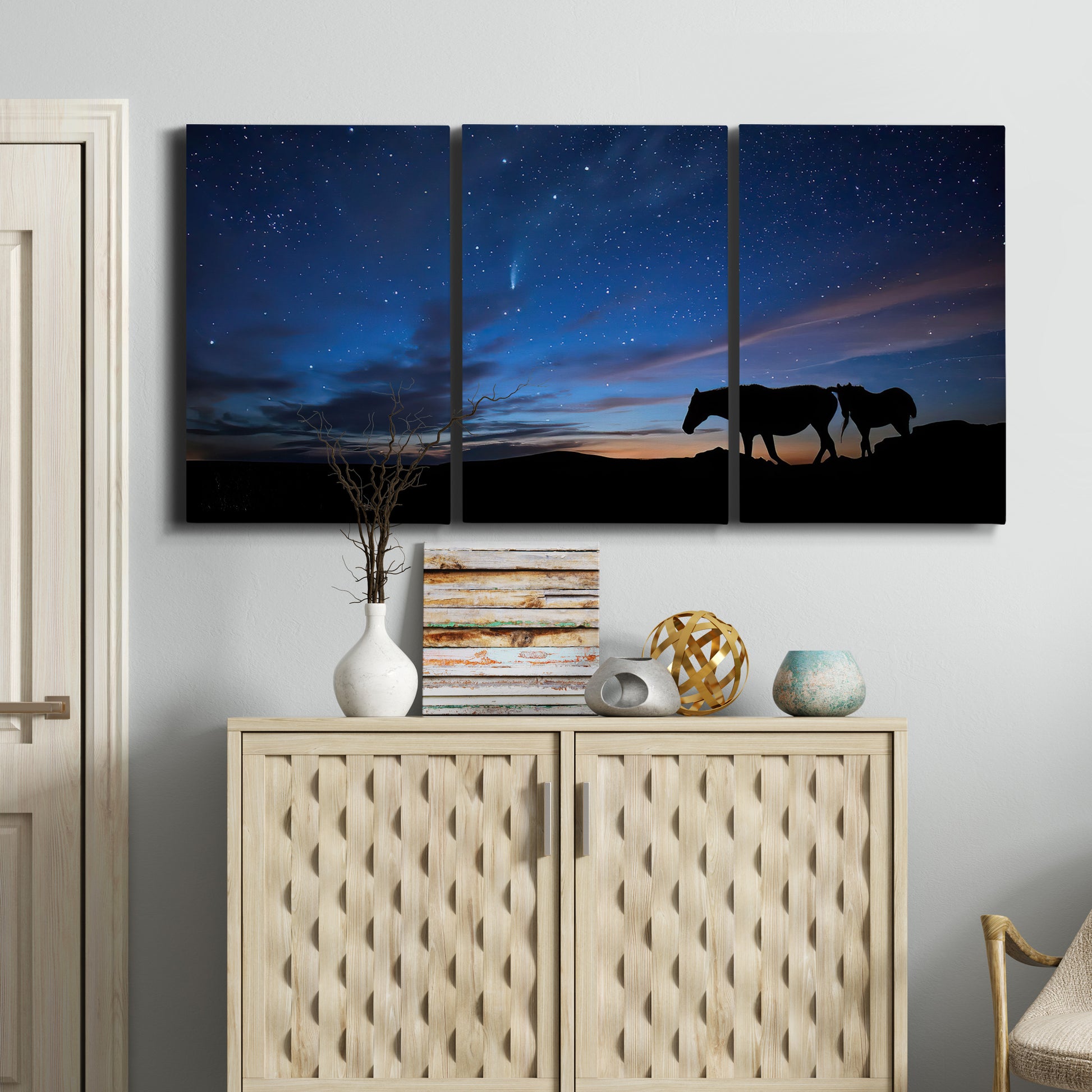 Three-panel canvas wall art featuring resting animals in open field, displayed above a cabinet in an entryway.