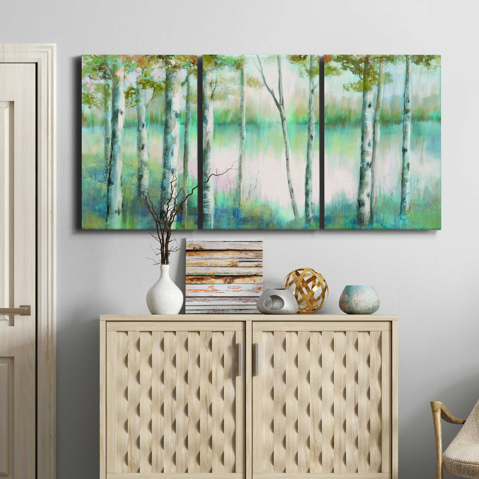 Three-panel canvas wall art featuring calm lake framed by aspen trees, displayed above a cabinet in an entryway.