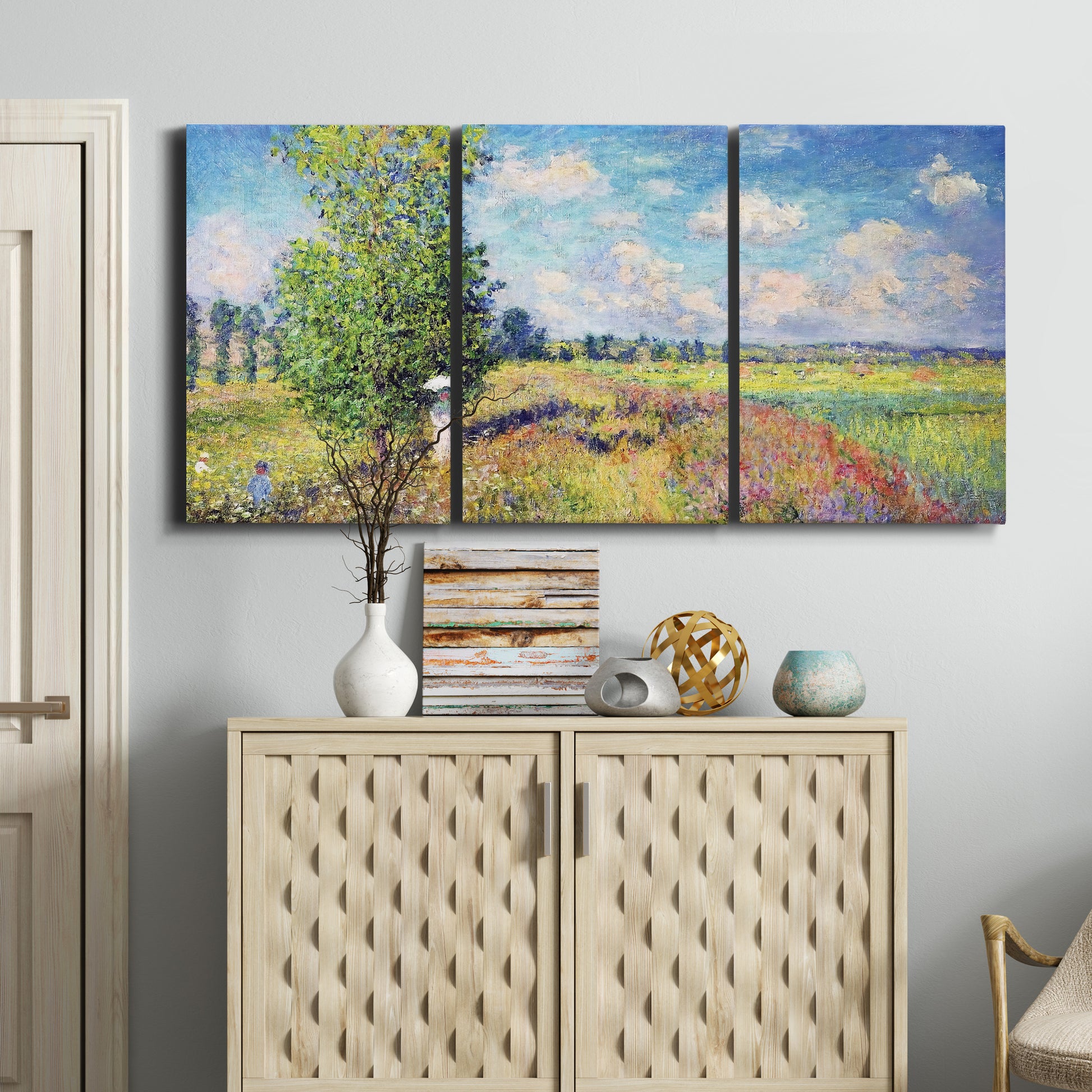 Three-panel canvas wall art featuring sunlit meadow landscape, displayed above a cabinet in an entryway.