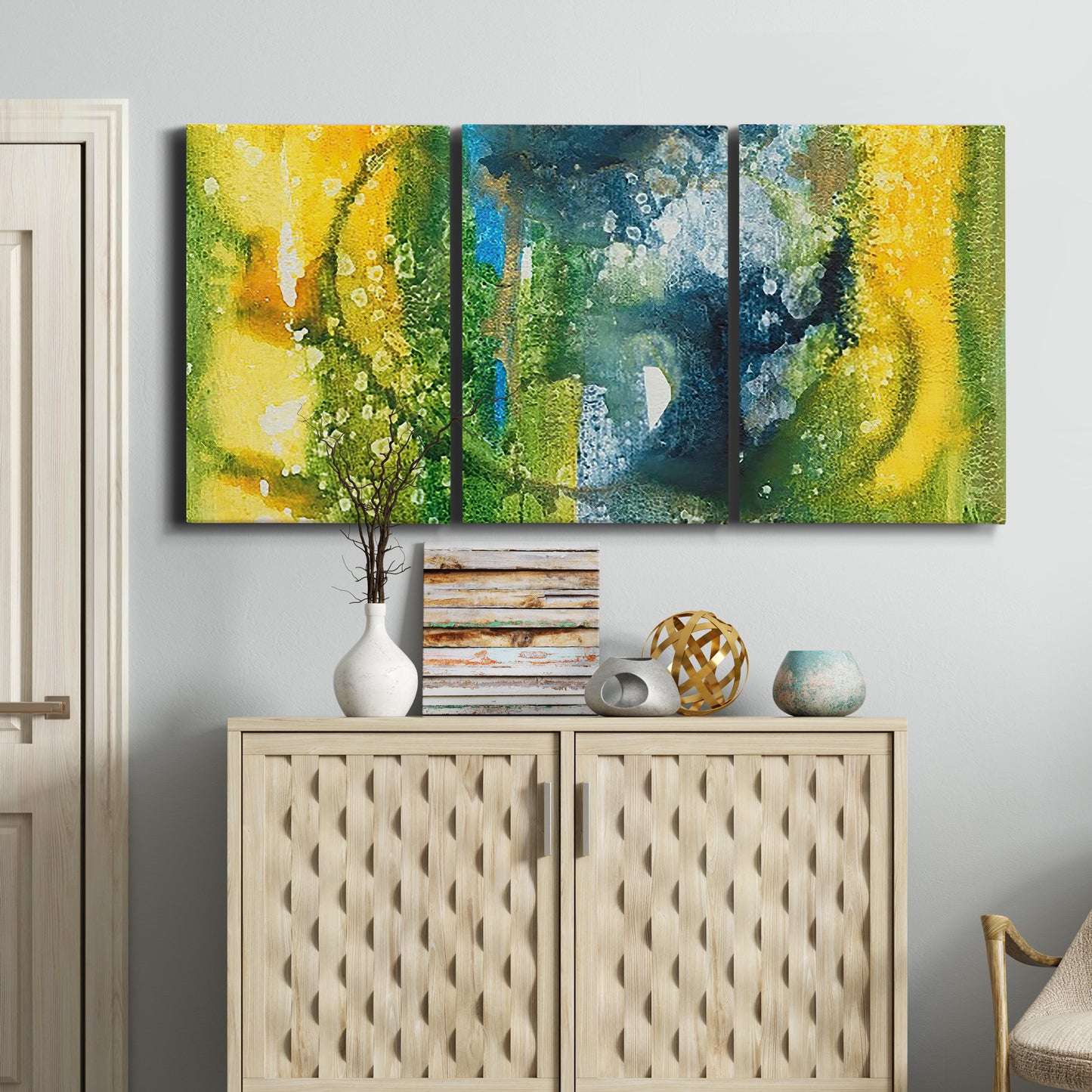 Three-panel canvas wall art featuring energetic abstract aquatic color motion, displayed above a cabinet in an entryway.