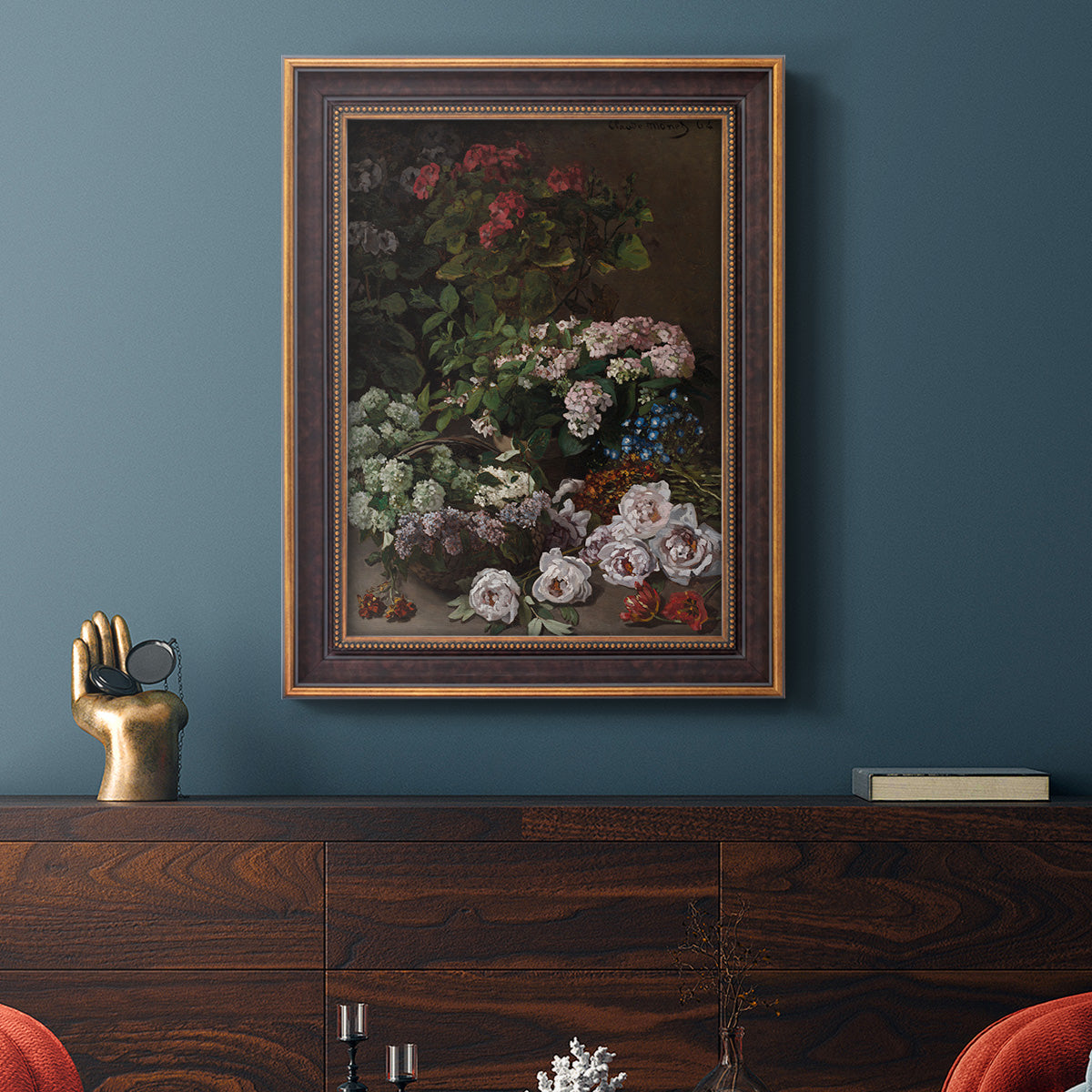 Early impressionist floral painting by Claude Monet in an ornate bronzed mahogany wood frame displayed in a dark-toned interior setting.