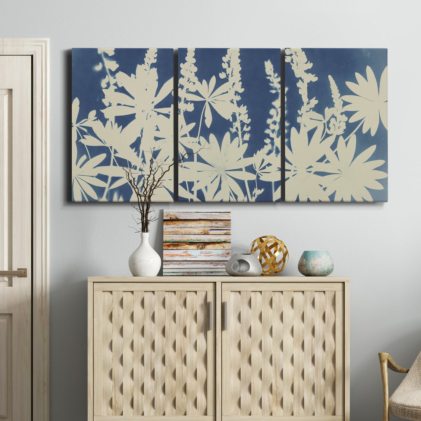 Three-panel canvas wall art featuring delicate lupine floral composition, displayed above a cabinet in an entryway.