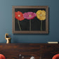 Contemporary poppy flower artwork in an ornate traditional bronze frame displayed in a dark-toned interior setting.