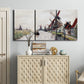Three-panel canvas wall art featuring windmills beside calm water, displayed above a cabinet in an entryway.