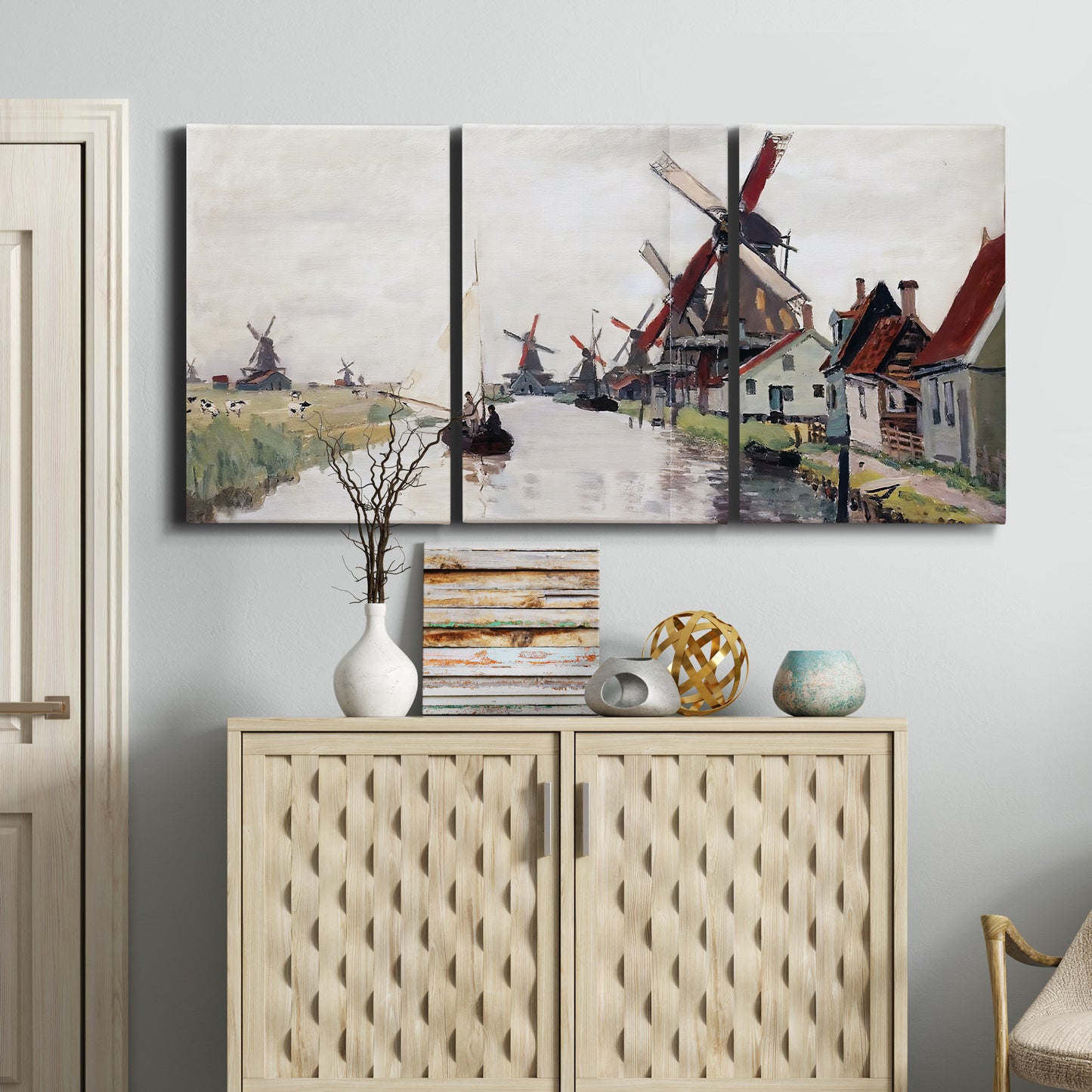 Three-panel canvas wall art featuring windmills beside calm water, displayed above a cabinet in an entryway.