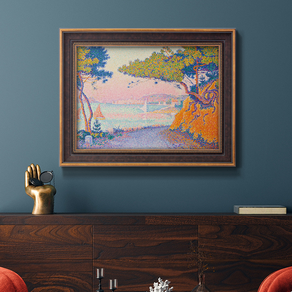 Pointillist coastal seascape by Paul Signac in an ornate bronzed mahogany wood frame displayed in a dark-toned interior setting.