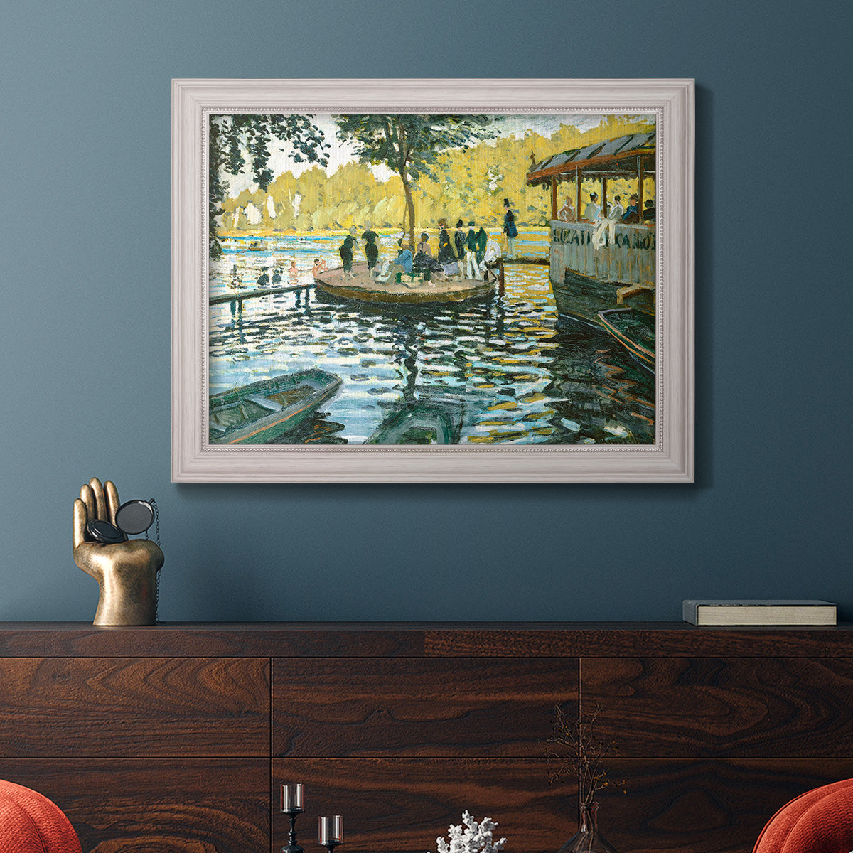 Impressionist riverside leisure scene by Claude Monet in an ornate weathered white frame displayed in a dark-toned interior setting.