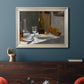 Impressionist still life with wine and bread by Claude Monet in an ornate champagne frame displayed in a dark-toned interior setting.