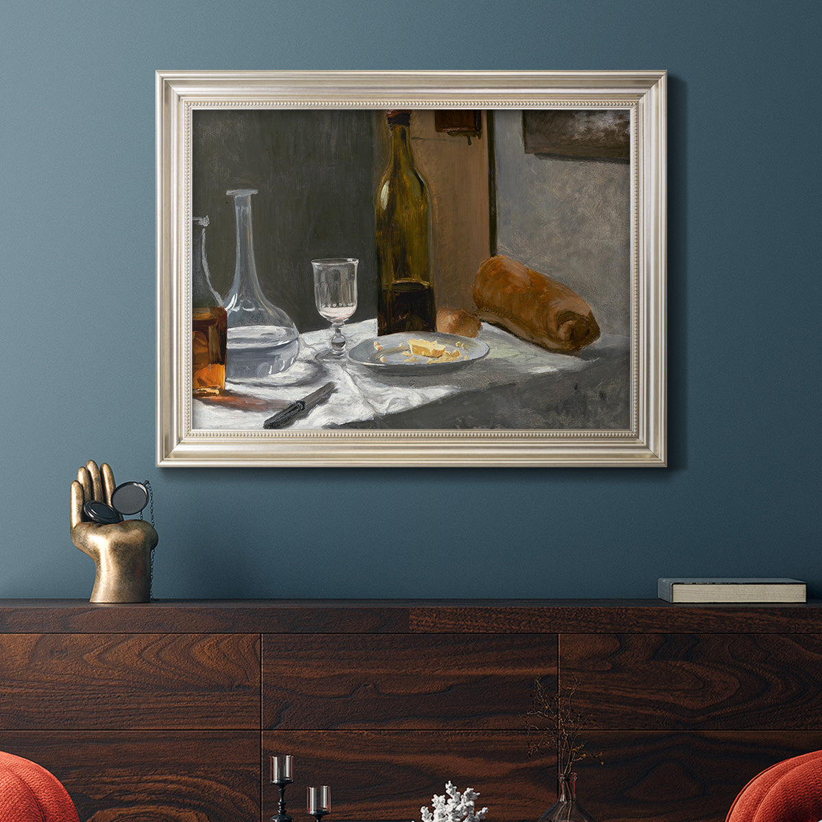 Impressionist still life with wine and bread by Claude Monet in an ornate champagne frame displayed in a dark-toned interior setting.