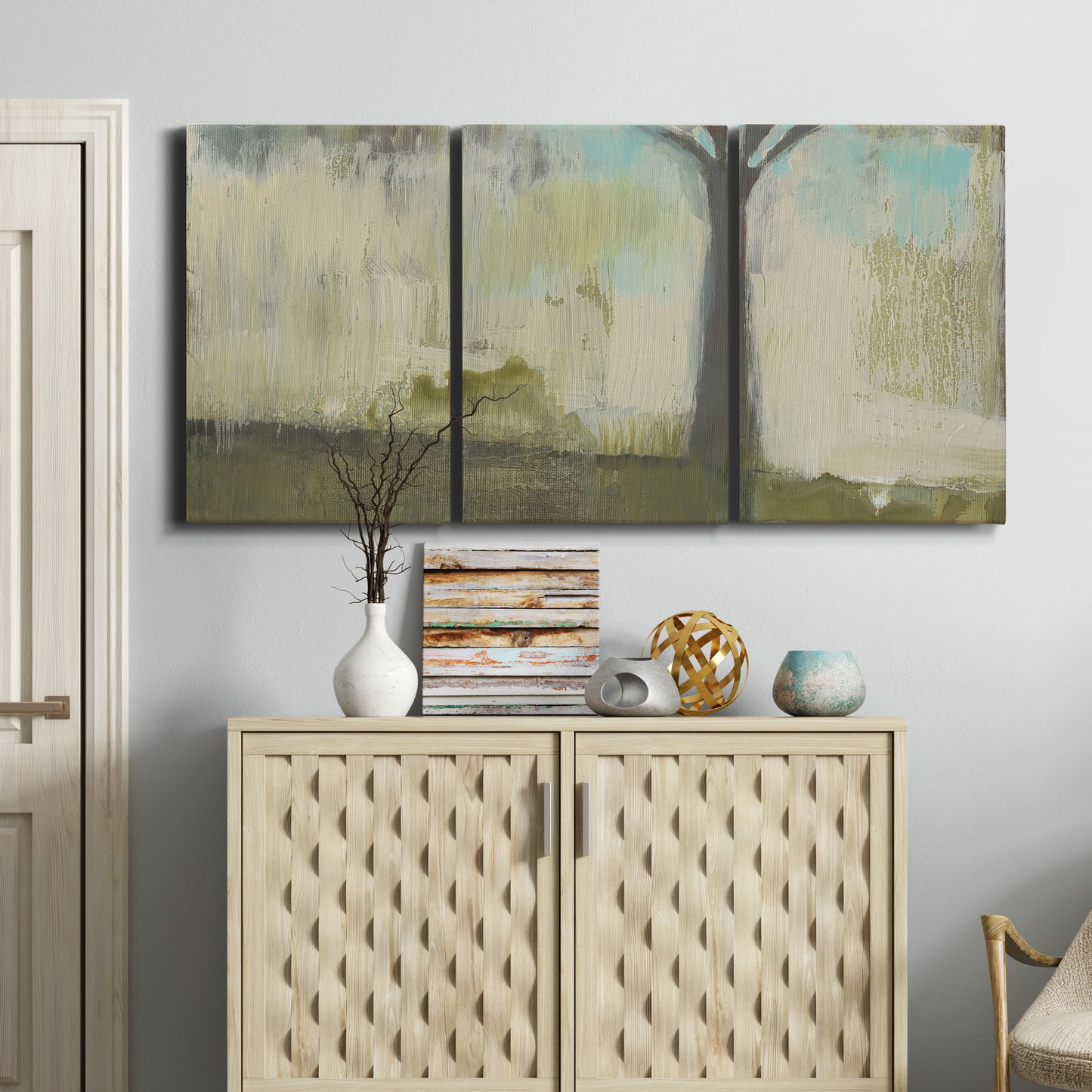 Three-panel canvas wall art featuring tall abstract tree form, displayed above a cabinet in an entryway.