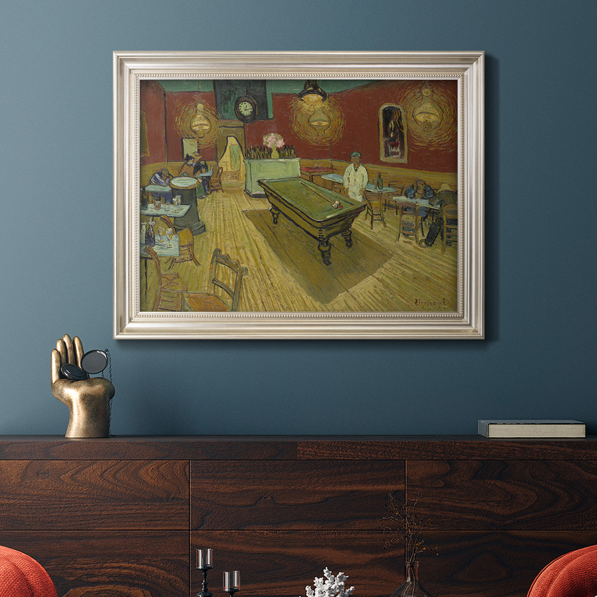 Impressionist interior of a night café by Vincent van Gogh in an ornate champagne frame displayed in a dark-toned interior setting.