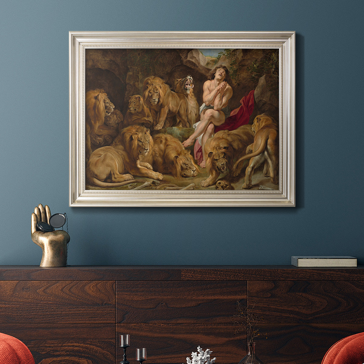 Dramatic biblical painting of Daniel with lions by Peter Paul Rubens in an ornate champagne frame displayed in a dark-toned interior setting.