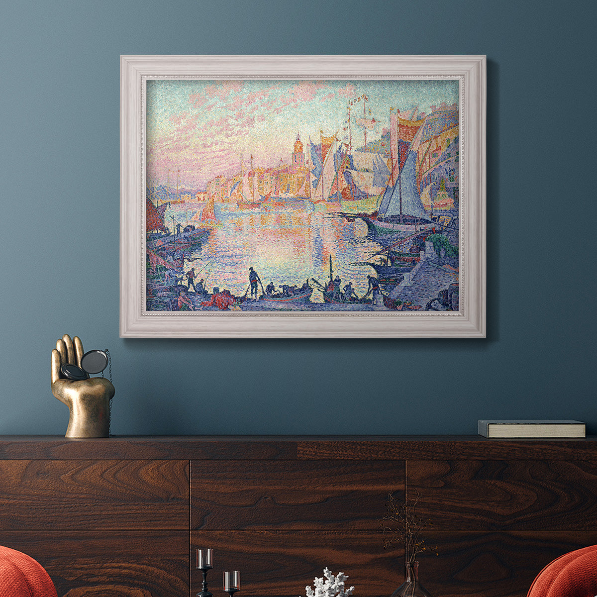 Impressionist Mediterranean harbor painting by Paul Signac in an ornate weathered white frame displayed in a dark-toned interior setting.