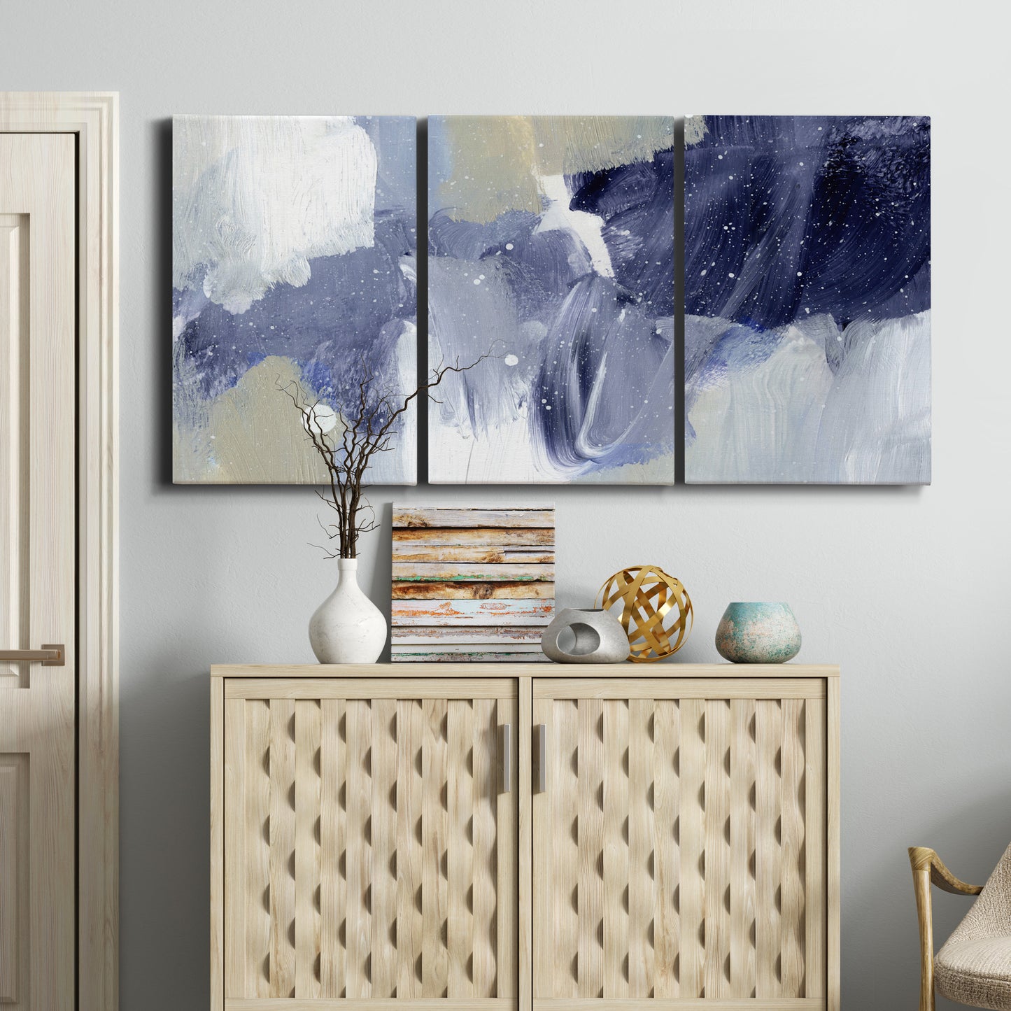 Three-panel canvas wall art featuring abstract sky break composition, displayed above a cabinet in an entryway.
