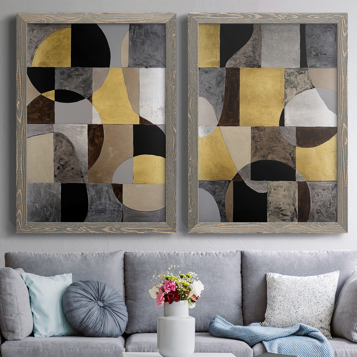 Set of two gray barnwood framed canvas prints depicting paired structured modern abstracts with semicircles, rectangles, textured panels, and metallic-looking accents above a sofa in a contemporary living room.