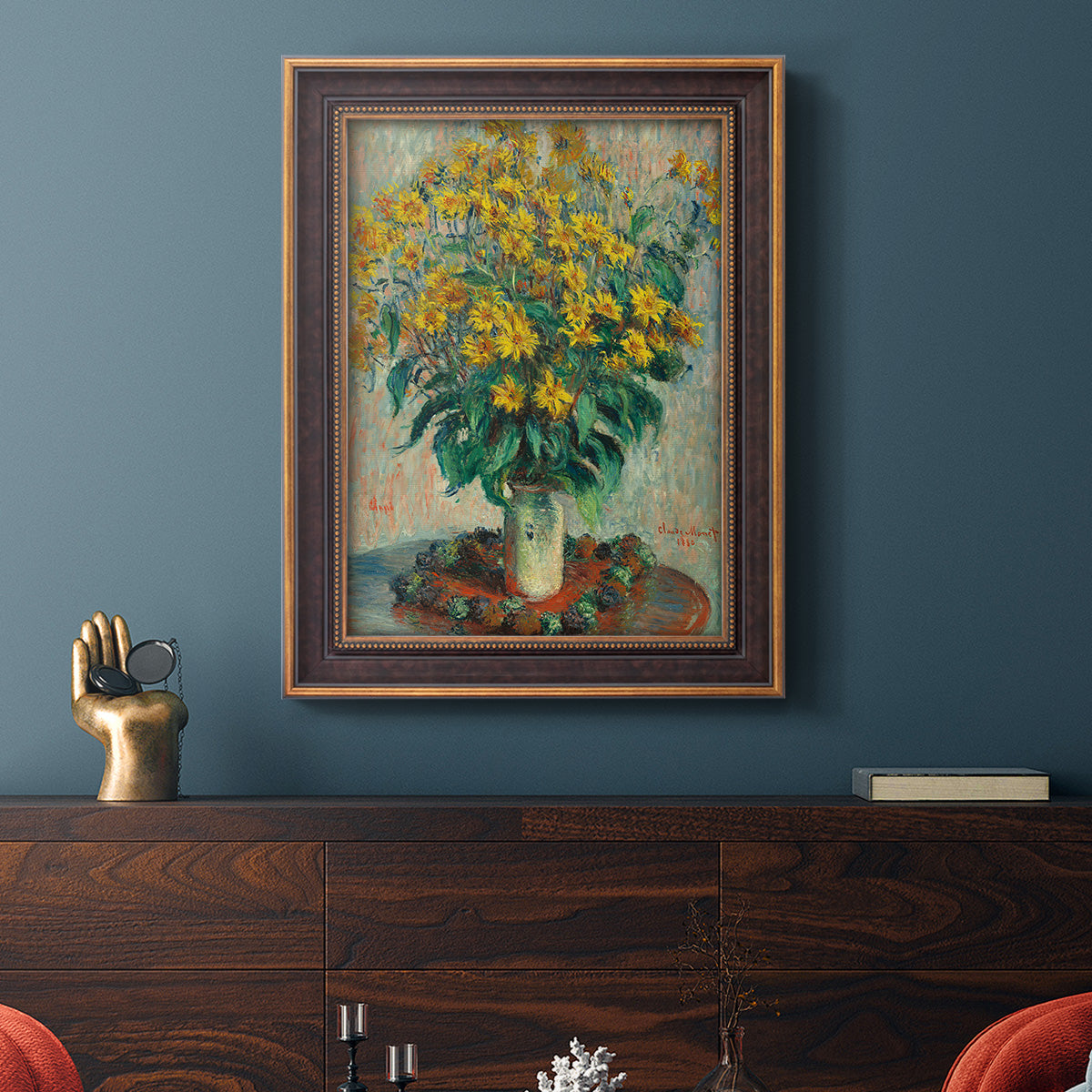 Impressionist floral painting of artichoke flowers by Claude Monet in an ornate bronzed mahogany wood frame displayed in a dark-toned interior setting.