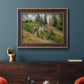 Impressionist countryside harvest scene by Camille Pissarro in an ornate bronzed mahogany wood frame displayed in a dark-toned interior setting.