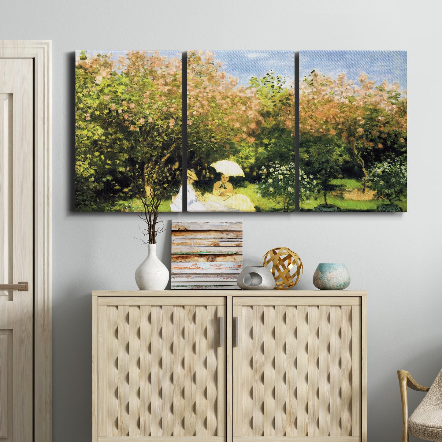 Three-panel canvas wall art featuring lush garden landscape with trees, displayed above a cabinet in an entryway.