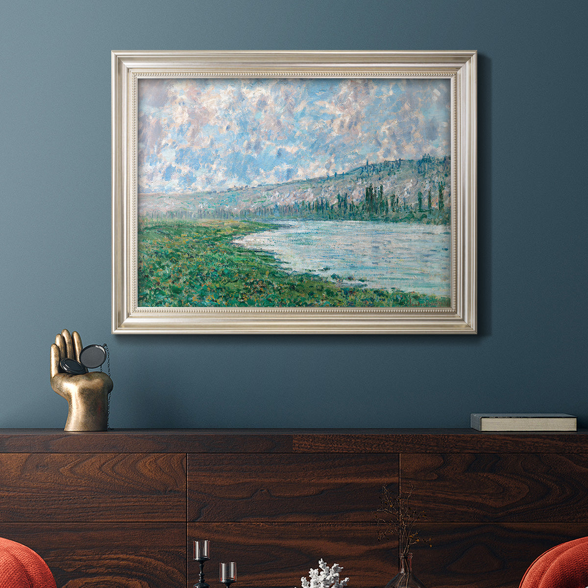 Impressionist river landscape at Vétheuil by Claude Monet in an ornate champagne frame displayed in a dark-toned interior setting.