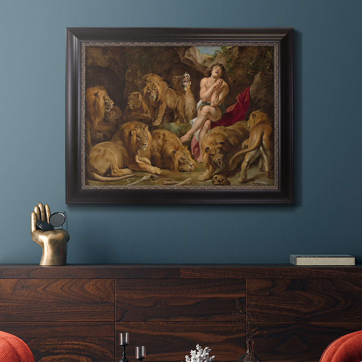 Dramatic biblical painting of Daniel with lions by Peter Paul Rubens in an ornate black frame with gilded inner detail displayed in a dark-toned interior setting.