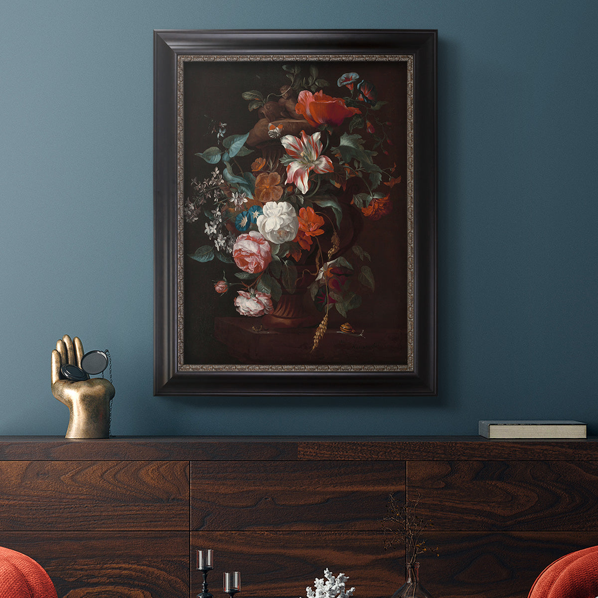 Classical floral still life painting by Jan van Huysum in an ornate black frame with gilded inner detail displayed in a dark-toned interior setting.