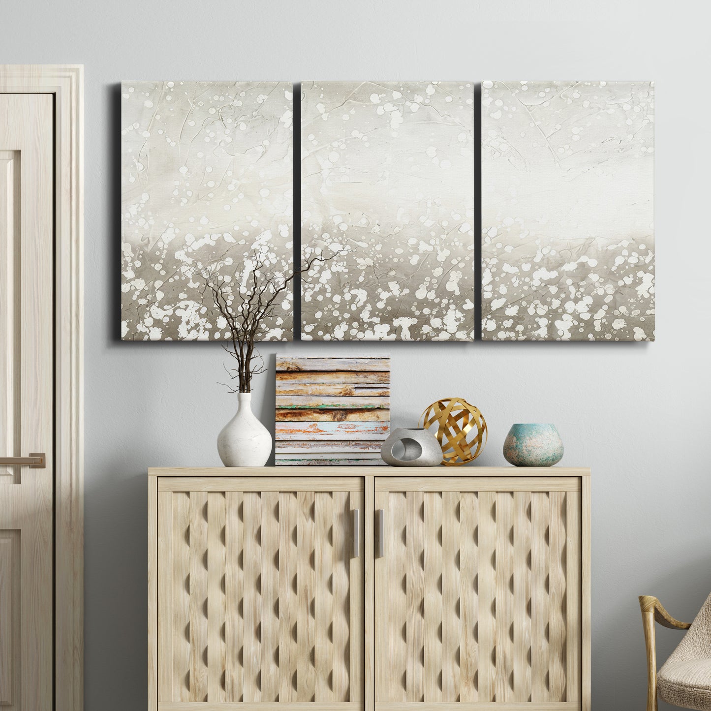 Three-panel canvas wall art featuring dark textured abstract mist, displayed above a cabinet in an entryway.