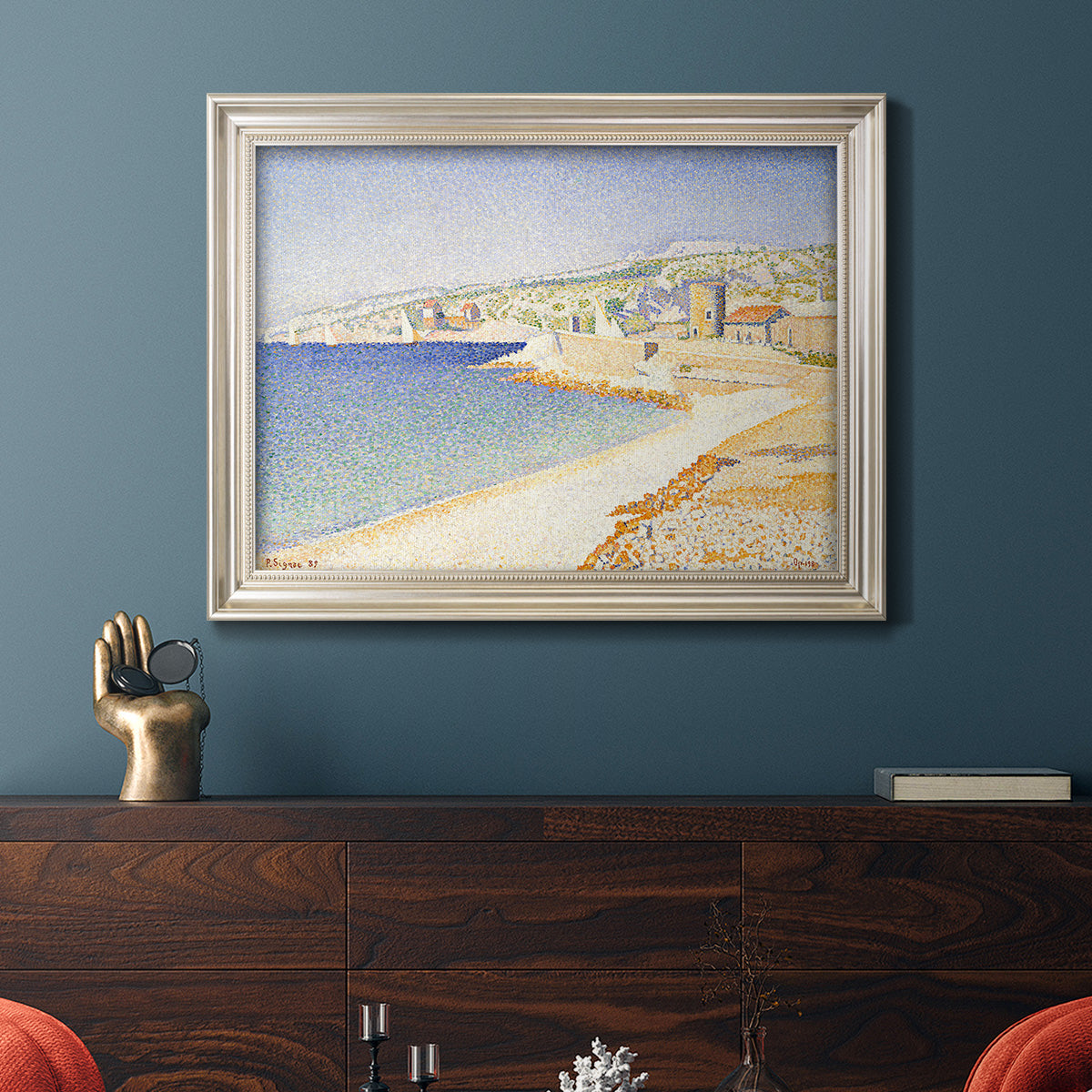 Impressionist Mediterranean jetty seascape by Paul Signac in an ornate champagne frame displayed in a dark-toned interior setting.