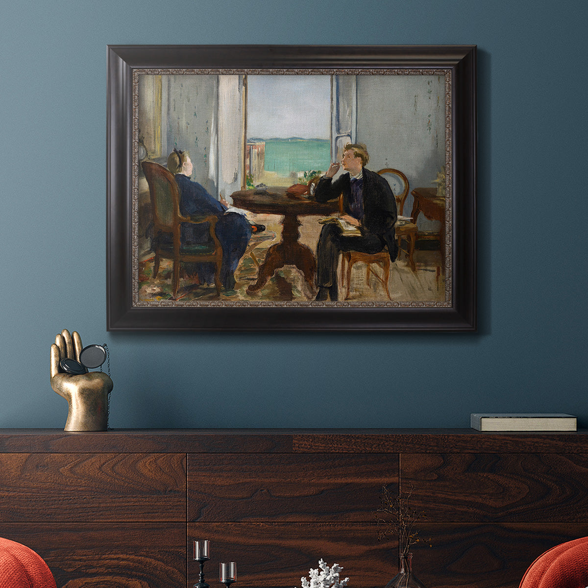 Impressionist interior scene by Édouard Manet in an ornate black frame with gilded inner detail displayed in a dark-toned interior setting.