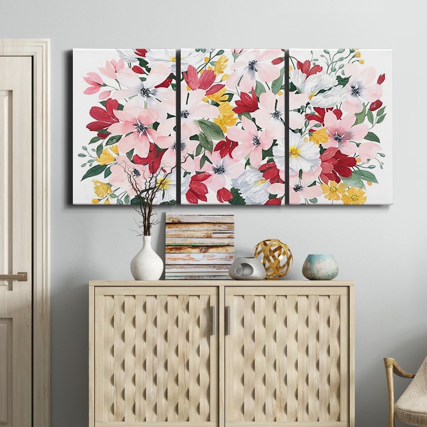 Three-panel canvas wall art featuring joyful spring floral composition, displayed above a cabinet in an entryway.