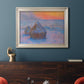 Impressionist haystack scene at sunset by Claude Monet in an ornate champagne frame displayed in a dark-toned interior setting.