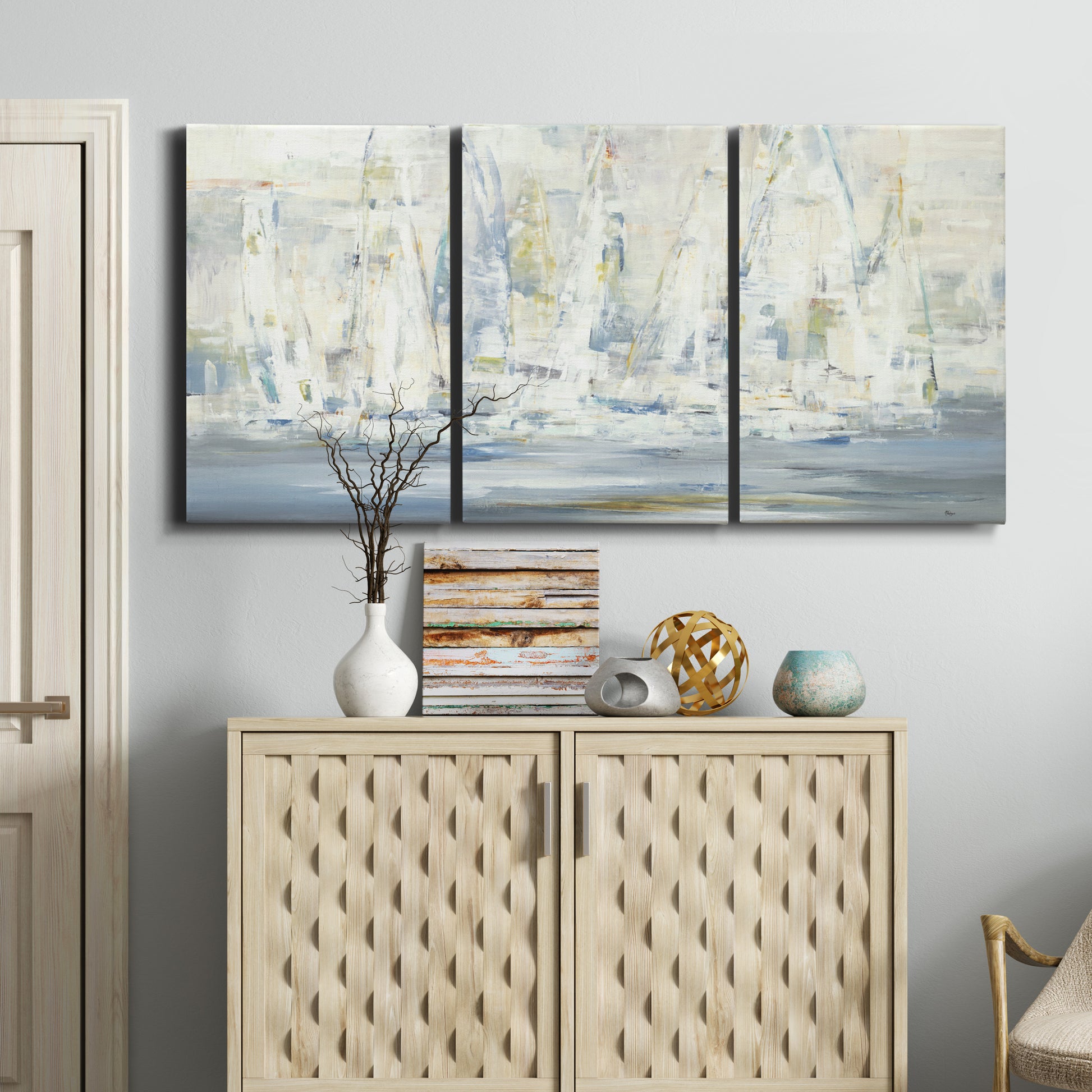 Three-panel canvas wall art featuring impressionist regatta scene with sailboats, displayed above a cabinet in an entryway.