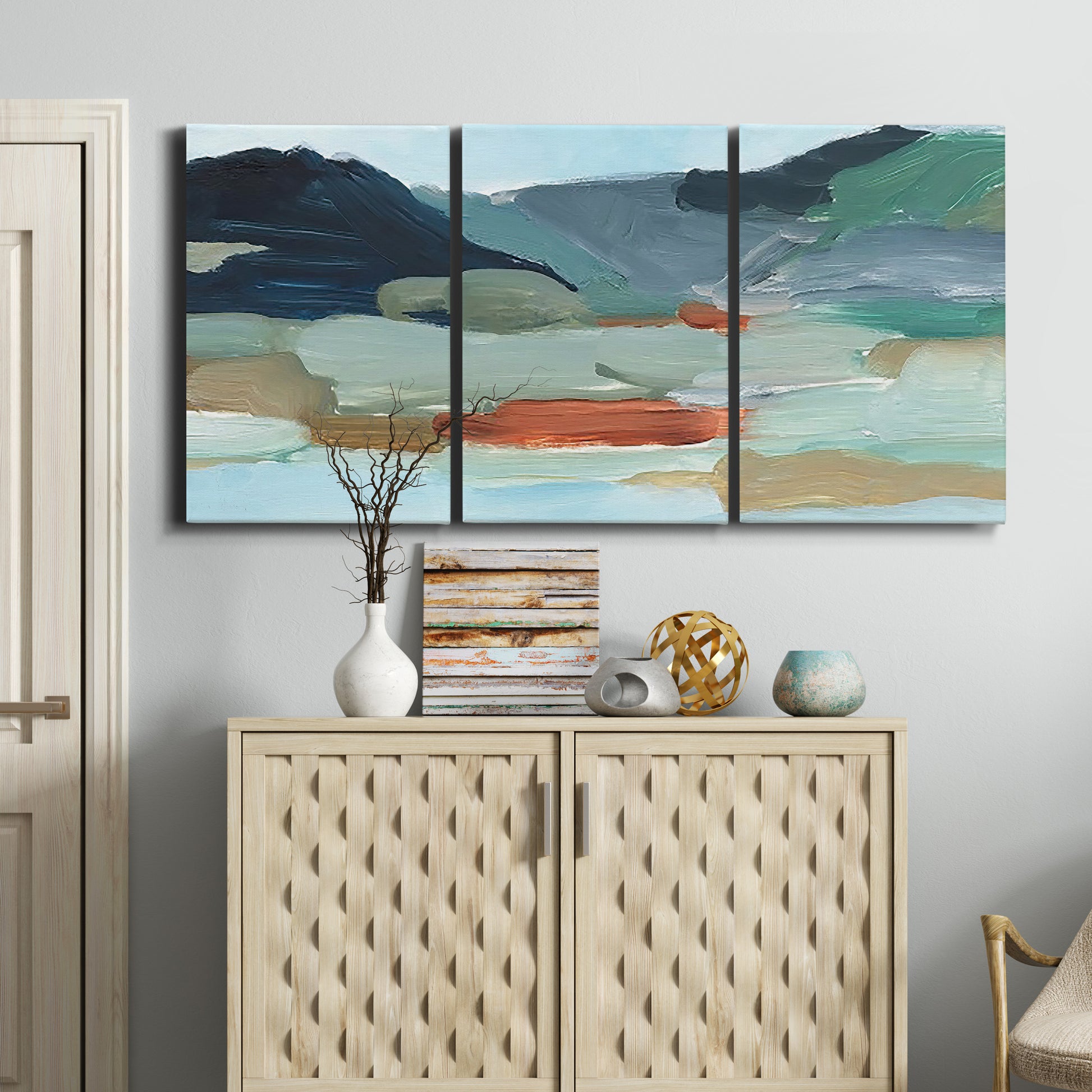 Three-panel canvas wall art featuring vibrant abstract with dramatic motion, displayed above a cabinet in an entryway.