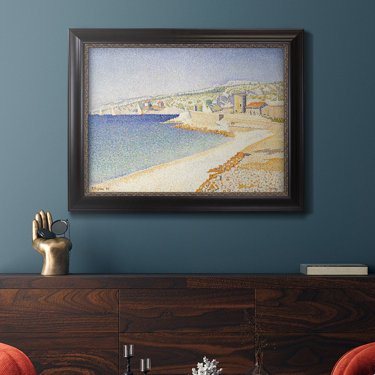 Impressionist Mediterranean jetty seascape by Paul Signac in an ornate black frame with gilded inner detail displayed in a dark-toned interior setting.